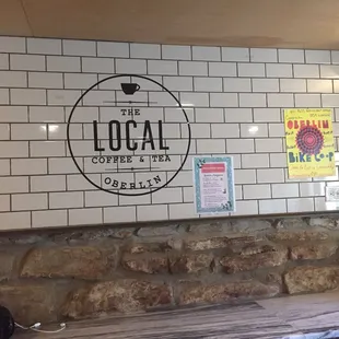 Crest stamped on the wall above a wall shelf/ counter for seating.