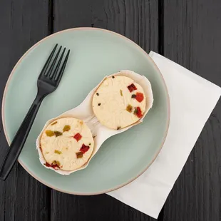 two burritos on a plate with a fork