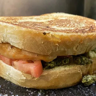 a grilled sandwich with tomatoes and pesto