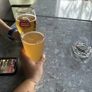 a person holding a glass of beer