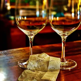 two glasses of wine on a bar