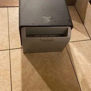 a microwave sitting on a tiled floor