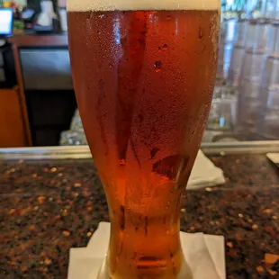 a glass of beer on a bar