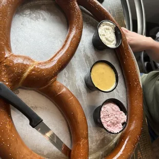a large pretzel and dipping sauces