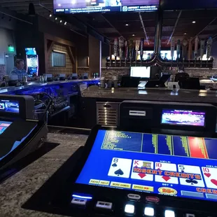 Dart board in background, slot machine