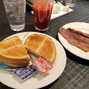 a plate of bacon and a sandwich