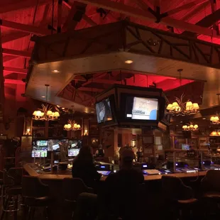 Main bar w red lighting &amp; a log cabin feel
