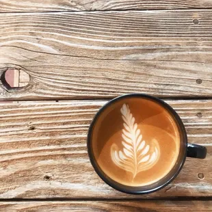 a cup of coffee on a wooden table