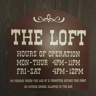 a sign for the loft hours of operation