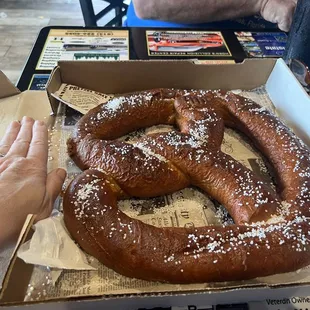 Using my hand to show the size of the pretzel comparison.