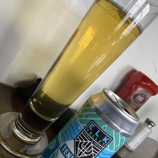 a glass of beer next to a can