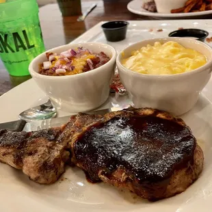 Juicy, well-cooked bone in pork chop with mac n cheese and chili