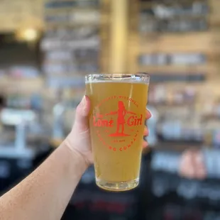 a hand holding a glass of beer