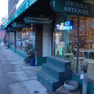 Front with awning, advertising, &amp; front window displays.