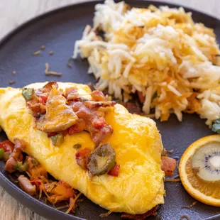 an omelet, hash browns, and a slice of orange