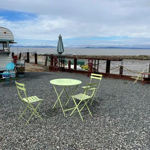 a table and chairs on a gravel patio