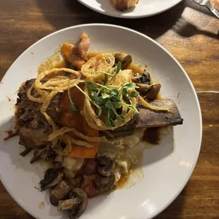 Braised short rib on a bed of mashed potatoes, mushrooms and prosciutto.  Delicious!!
