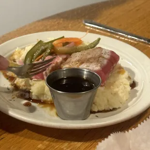 Seared Ahi tuna on mashed potatoes with veggies.