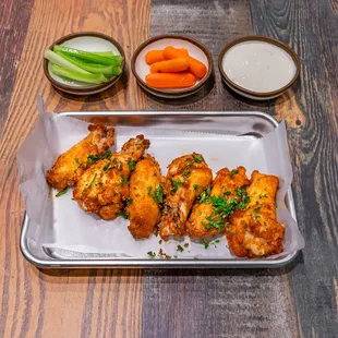 a tray of fried chicken wings and carrots