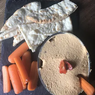 a platter of hummus, carrots and crackers