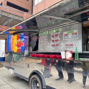 a couple of people walking past a food truck