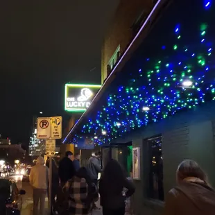 people walking down the sidewalk at night