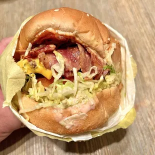 Lucky Burger Pastrami Cheeseburger. Thinly sliced, smoky pastrami over a juicy beef patty. It's got all the fixins in it.