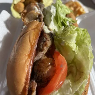 Steak Sandwich with Fried Mushrooms and French Fries in the back.