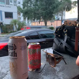 a can of beer and sunglasses on a table