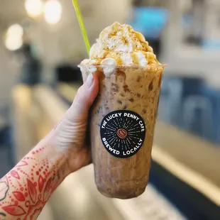 a hand holding a iced coffee