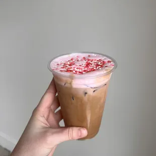 a hand holding a cup of iced coffee