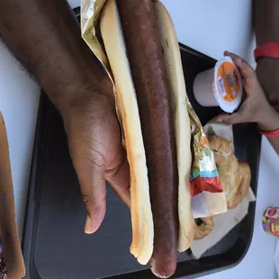 a person holding a hot dog