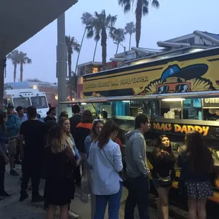 a line of people waiting at a food truck