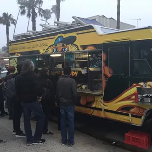a group of people standing in front of a food truck