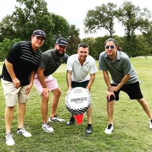 a group of men posing with a golf ball
