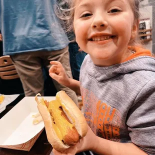 My daughter eating a hot dog