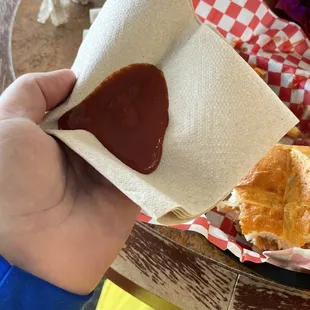 a person holding a napkin over a sandwich