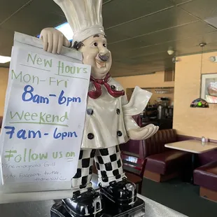 a statue of a chef holding a sign