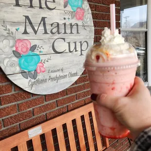 a hand holding a cup of ice cream