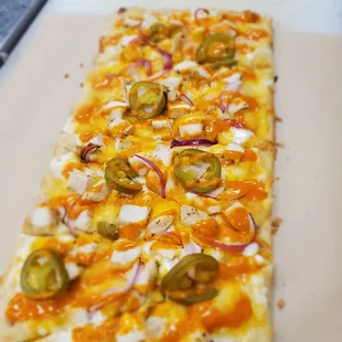 Buffalo Chicken Pizza with jalapenos, onions, blue cheese and buffalo sauce.