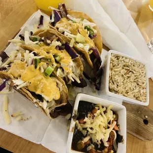 a plate of tacos, rice, and orange juice