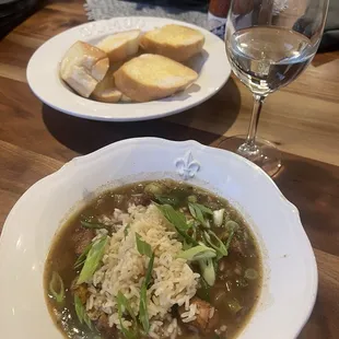 Chicken and sausage gumbo, with crusty bread and butter and a glass of Pinot