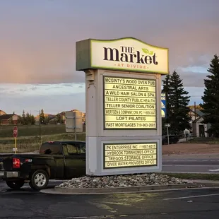 a truck parked in front of a sign