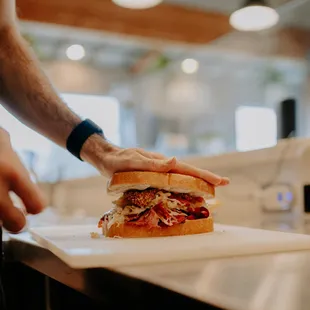 a person holding a sandwich