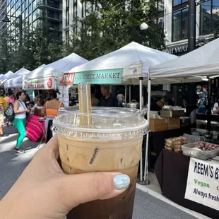 a hand holding a cup of iced coffee