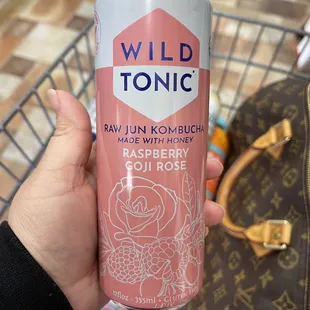 a person holding a can of wild tonic