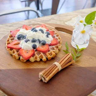 Chai waffle served with fresh fruit, whipped cream, and powdered sugar.