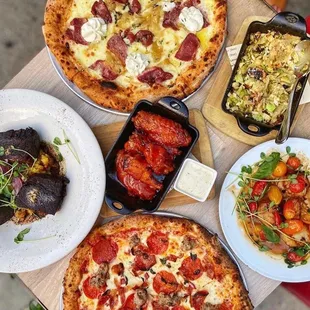 A spread of entrees, sides, and pizzas
