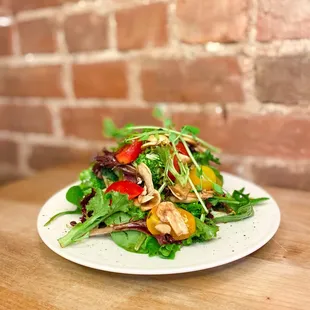 a plate of salad on a wooden table