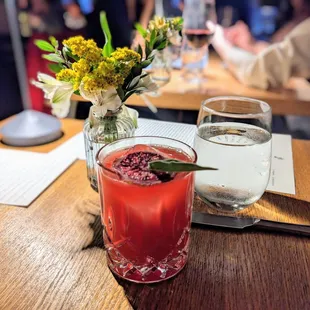 a glass of water and a drink on a table